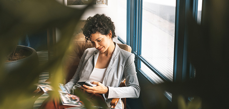 A smartly dressed woman relaxes in a comfortable chair with a magazine